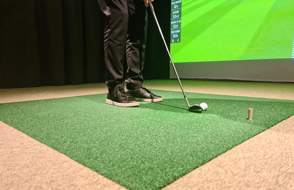 Person using a home golf simulator