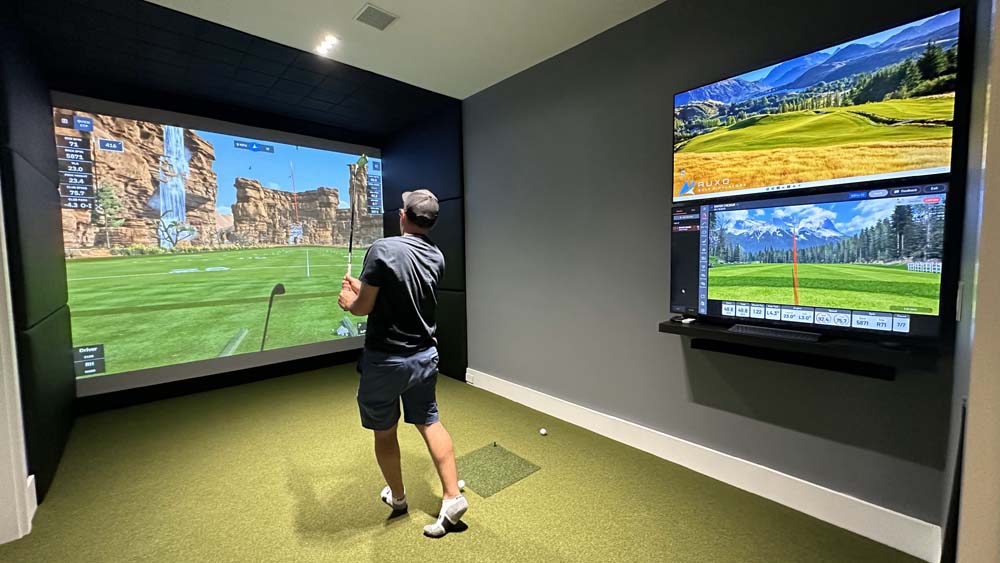 Person hitting on a residential golf simulator in their basement