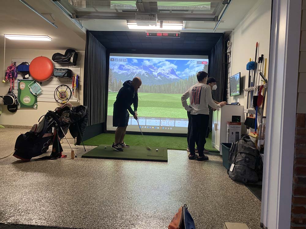 Man hitting on golf simulator